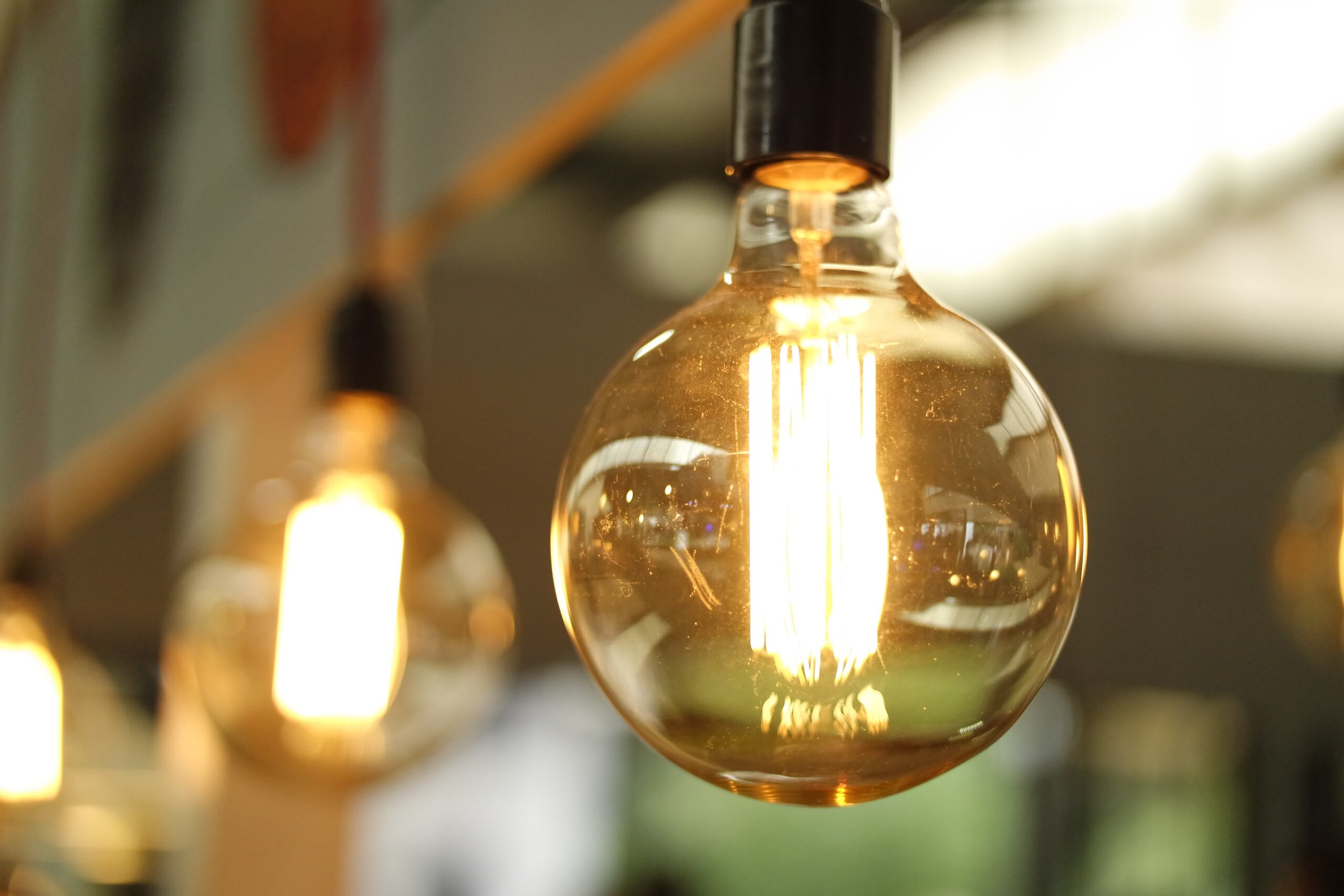 Zbliżenie na świecącą żarówkę Edison.