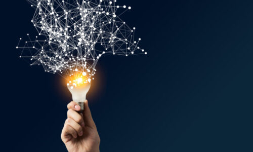 Ręka trzymająca żarówkę z siecią połączeń