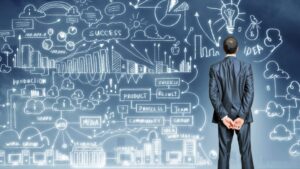 Mężczyzna przed tablicą z diagramami strategii biznesowej