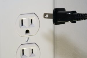 Wtyczka blisko gniazdka elektrycznego na ścianie
