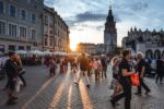 Tłum na rynku w Krakowie o zachodzie słońca.