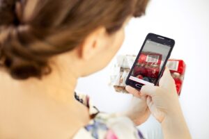 Osoba skanuje kod kreskowy paczki telefonem.