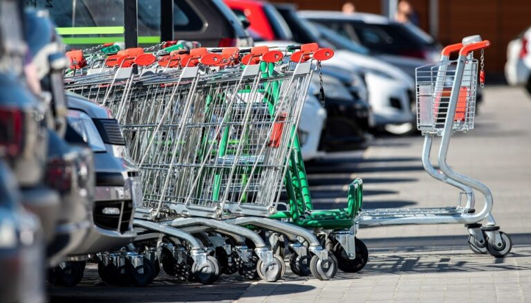 Wózki sklepowe na parkingu przed supermarketem.