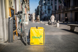 Rower Glovo z żółtym plecakiem na ulicy