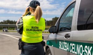 Funkcjonariuszka celna obserwuje drogę z pojazdu.