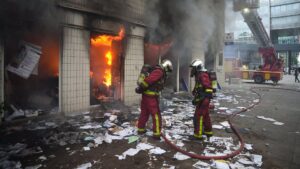 Strażacy gaszą budynek podpalony przez uczestników zamieszek