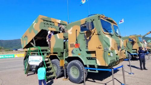 Militarny pojazd na pokazie z ludźmi oglądającymi.
