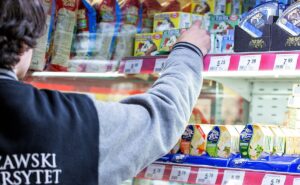 Osoba wybiera produkt w sklepie spożywczym