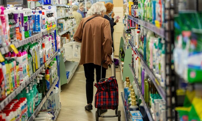 Osoba z wózkiem robi zakupy w sklepie.