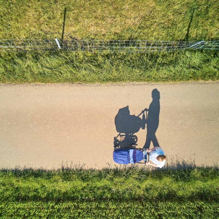 Osoba z wózkiem spaceruje po ścieżce.