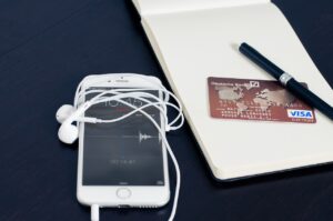 Smartfon, karta kredytowa, słuchawki, notatnik, długopis
