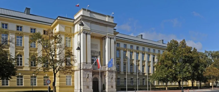Budynek rządowy z flagami w otoczeniu drzew