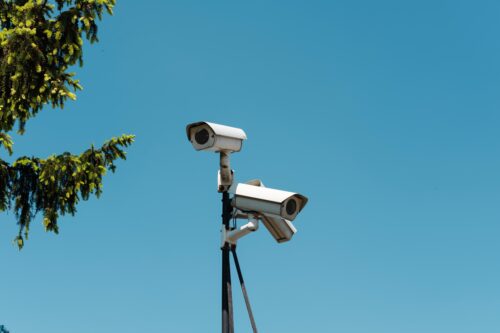 Kamery monitoringu na tle nieba i drzew
