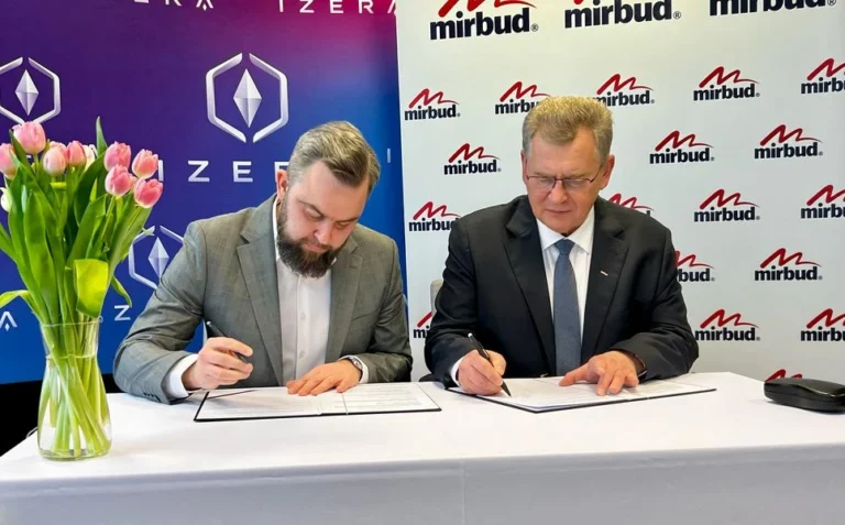 Dwóch mężczyzn podpisuje dokumenty na spotkaniu