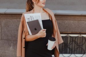 Kobieta z tabletem, gazetą i kawą w ręku