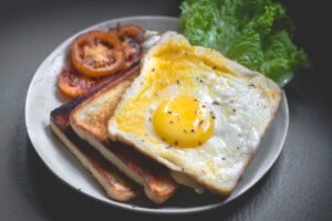 Tost z jajkiem i pomidorem na talerzu