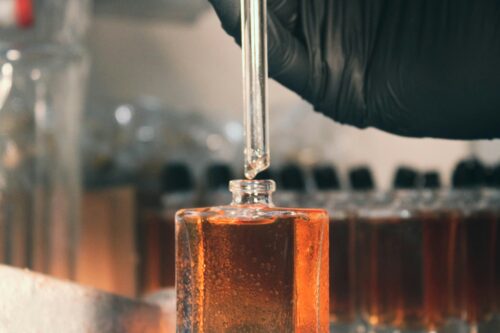 Pipeta wlewa ciecz do butelki, laboratorium.