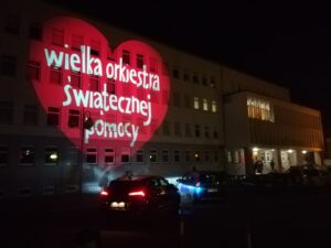 Projekcja serca z napisem na budynku nocą.