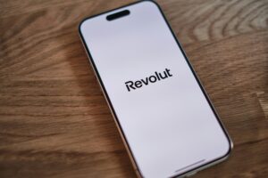 Logo Revolut na ekranie smartfona na stole