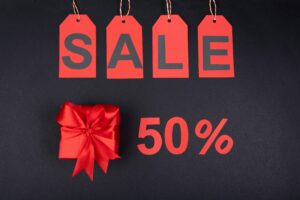 Wyprzedaż 50% zniżki, czerwone etykiety, prezent.