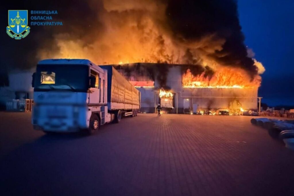 Pożar magazynu, płonący budynek nocą