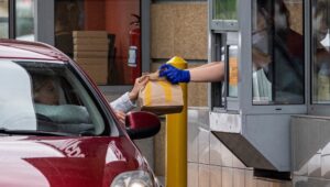 Drive-thru, samochód odbiera zamówienie przy okienku.