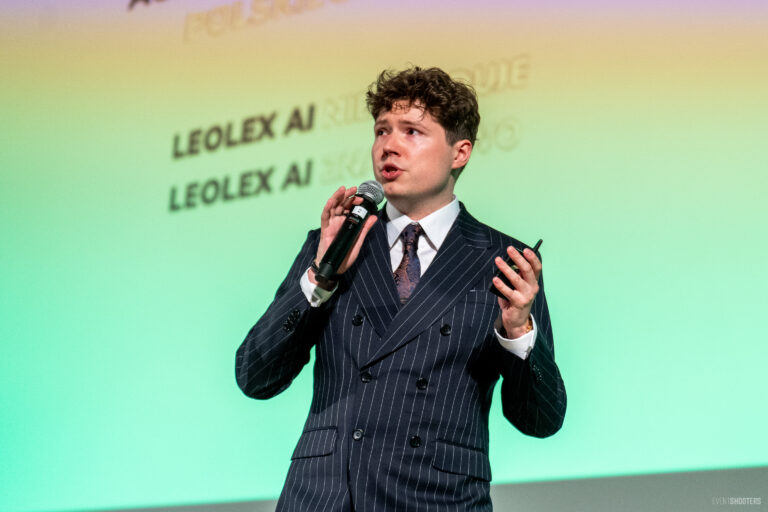 Michał Gaszewski przemawia na konferencji. W tle napisz Leolex AI