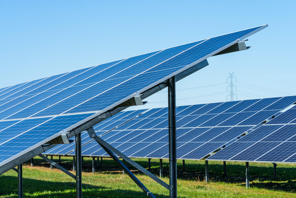 Panele słoneczne na polu, niebieskie niebo.