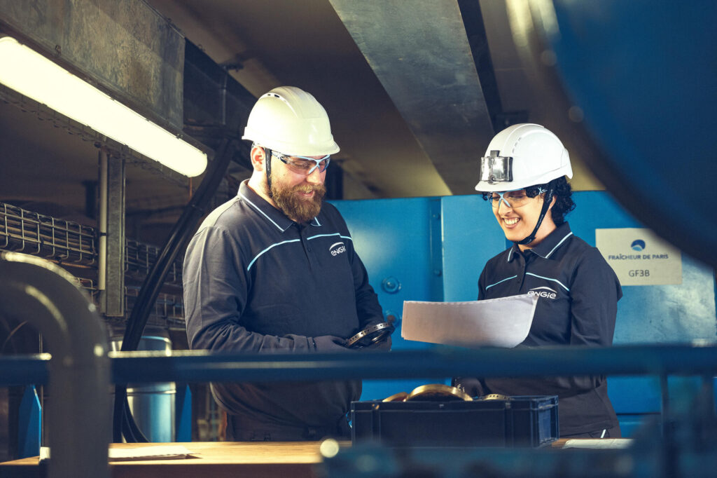 Pracownicy fabryki w kaskach analizują dokumenty