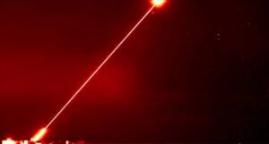 Czerwony promień lasera na nocnym niebie.