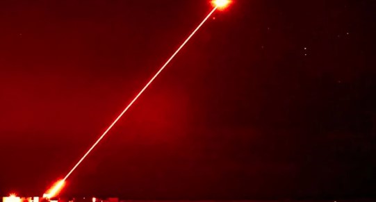 Czerwony promień lasera na nocnym niebie.