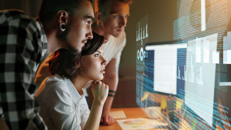 Zespół analizuje dane na ekranie komputerów