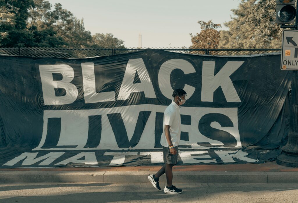 Osoba przed banerem Black Lives Matter