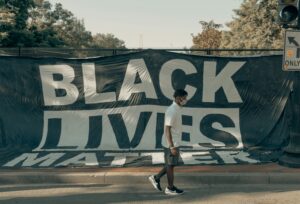 Osoba przed banerem Black Lives Matter