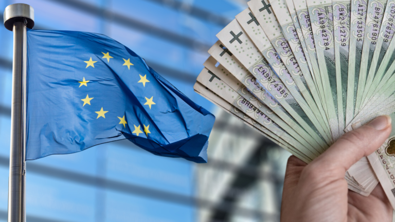 Flaga UE i banknoty euro w ręku