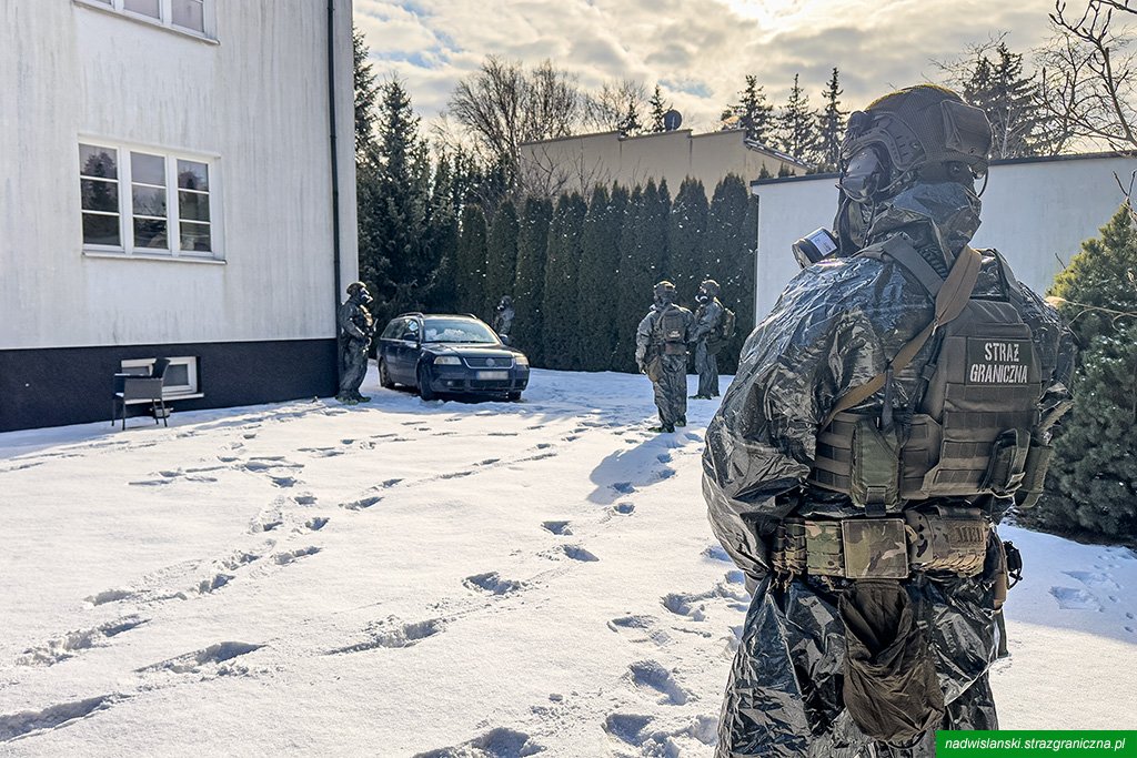 Straż Graniczna operacja zimowa na zaśnieżonym podwórku.