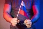 Człowiek zrosyjsą flagą i kajdanki