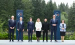 Przywódcy państw pozują przed banerami C8 wśród lasów