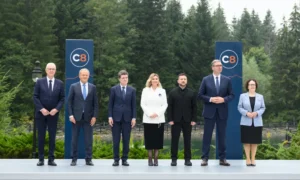 Przywódcy państw pozują przed banerami C8 wśród lasów