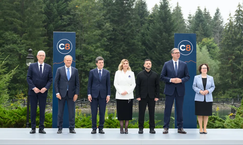Przywódcy państw pozują przed banerami C8 wśród lasów