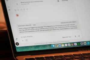 Ekran laptopa z odpowiedzią AI i klawiaturą MacBooka