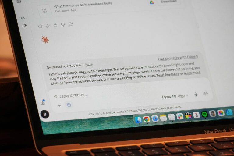 Ekran laptopa z odpowiedzią AI i klawiaturą MacBooka