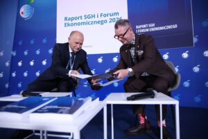 Dwaj mężczyźni podpisują dokumenty na Forum Ekonomicznym SGH