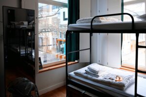 Metalowe łóżka piętrowe w jasnym pokoju hostelowym