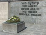 Pomnik Zagłady z wieńcem i napisem „Nigdy więcej”