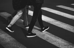 Dwie osoby w sneakersach siedzą na betonowych schodach