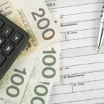 Kalkulator, polskie banknoty i formularze podatkowe.