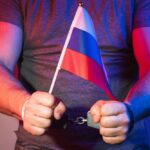 Człowiek zrosyjsą flagą i kajdanki
