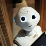 Biały robot z kamerami i niebieskim podświetleniem