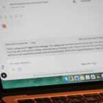 Ekran laptopa z odpowiedzią AI i klawiaturą MacBooka